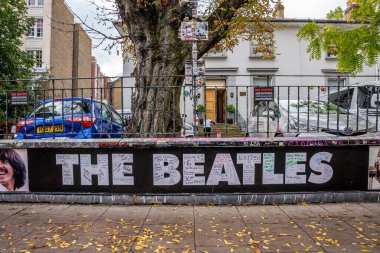 Evin önündeki Abbey Yolu 'nda park etmiş arabaların olduğu Beatles tabelası.