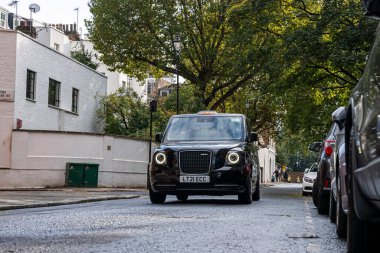 Geleneksel siyah bir taksiye binip Londra sokaklarında