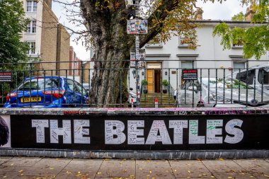 Evin önündeki Abbey Yolu 'nda park etmiş arabaların olduğu Beatles tabelası.