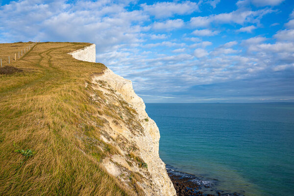 Beautiful scenery of white cliffs along blue sea on sunny day