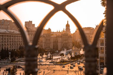 Kyiv, Ukrayna. 20 Temmuz 2021. Gün batımında şehir silueti, Independence Meydanı 'ndaki Globus merkez alışveriş merkezi Aziz Sophia Katedrali ve diğer kentsel binaların yanındaki çeşmeler.
