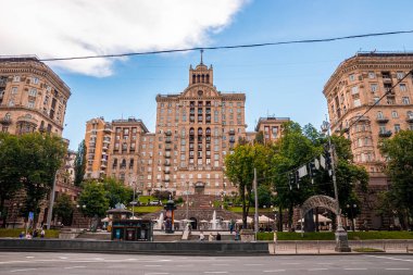 Kyiv, Ukrayna. 20 Temmuz 2021. Kyiv, Ukrayna. 20 Temmuz 2021. Üzerinde bir yıldız olan tarihi Stalinist tarzı bina cephesi, su çeşmesi ve depoların yanındaki yayalar hareket halinde.