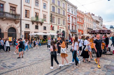 Lviv, Ukrayna. 20 Temmuz 2021. Kaldırımlı caddelerde yürüyen yayalar ve konut binalarına karşı tezgahlar..
