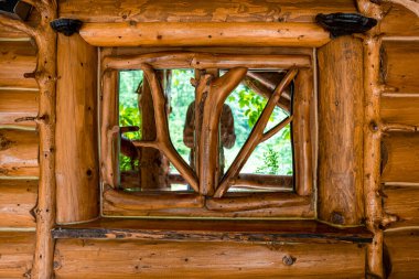 Kapalı ahşap desenli pencerenin camına yansıyan kişi, dekoratif pencere çerçeveli kütük duvarı