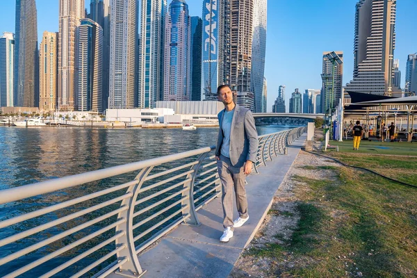 Young man walking at the promenade in Dubai Marina. — Stock Photo, Image