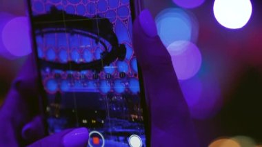 İnsanlar cep telefonlarını canlı konser programında çekiyorlar.