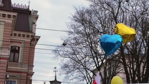 라트비아의 리가에 있는 러시아 대사관 옆에 있는 우크라이나 컬러 풍선. — 비디오