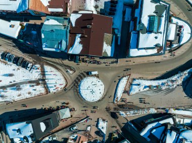 Avusturya 'nın kayak merkezi St. Anton am Arlberg' de kış güneşli gökyüzü ve arka planda çam ağaçlarıyla kaplı karlı dağlar.