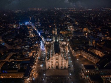 Merkezdeki gotik katedralin önündeki Piazza Duomo 'nun hava manzarası. Geceleri galerinin ve çatıların insansız hava aracı görüntüsü. Gece Milano, İtalya,