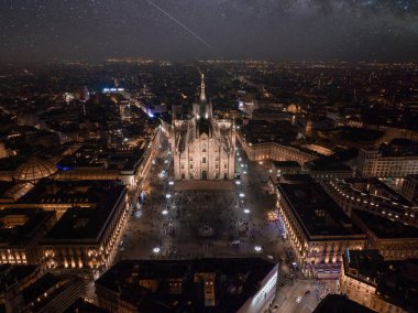 Merkezdeki gotik katedralin önündeki Piazza Duomo 'nun hava manzarası. Geceleri galerinin ve çatıların insansız hava aracı görüntüsü. Gece Milano, İtalya,