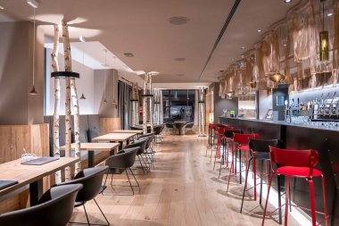 Sandalyeler ve masalar tezgah tarafından ayarlandı. Lüks oteldeki boş modern restoran. Otelde aydınlatılmış dekoratif salon..