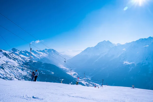 スキーのためのTバースキーリフトを使用して観光客 雪に覆われた風景を楽しむ人々 晴れた日の青空との山の範囲 — ストック写真