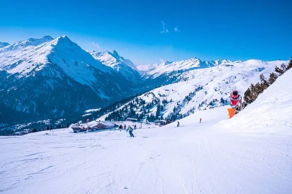 Skiërs Skiën Besneeuwde Afdaling Prachtige Witte Bergketen Tegen Blauwe Lucht — Stockfoto