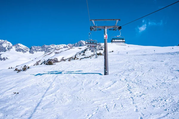 Stoeltjeslift Besneeuwde Berg Skilift Reikt Naar Bereik Tegen Blauwe Lucht — Stockfoto