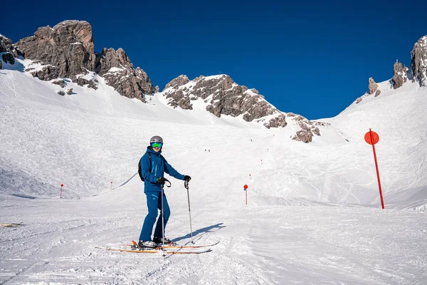 圣Anton Arlberg 2022年3月10日 年轻男子穿着滑雪服 两根杆站在雪山的背景下 男子滑雪者两根杆站在滑雪胜地的山坡上 — 图库照片