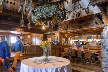 Aziz Anton am Arlberg. 10 Mart 2022. Süslü otel lobisindeki masaya yerleştirilmiş cam vazodaki güzel çiçekler oteldeki masanın üzerine yerleştirilmiş vazolar.