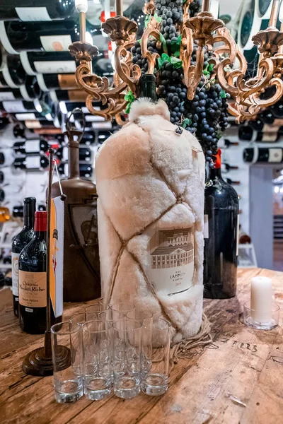 セント アントンはアールバーグだ 2022年3月10日 現代的なワイン店で木製のテーブルの上にショットグラスとワインボトル 店内のテーブルの上にガラスと装飾されたワインボトル — ストック写真