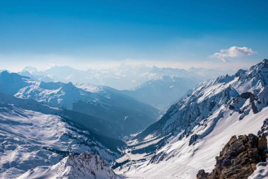 Karla kaplı dağ manzarası. Gökyüzüne karşı beyaz manzaranın yüksek açılı görüntüsü. Kışın güzel manzarası.