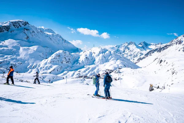 Aziz Anton am Arlberg. 10 Mart 2022. Kayakçılar güneşli bir günde, karlı dağlarda direkleri tutan kayakçılar, karlı dağlarda ayakta duran kayakçılar.