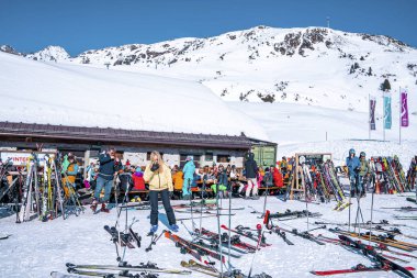 Aziz Anton am Arlberg. 10 Mart 2022. Kayak tatili sırasında kayak merkezindeki açık kafede oturan insanlar, güneşli bir günde dağ kafede oturan turistler.