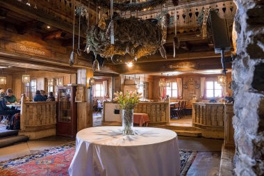 Ortadaki masada çiçek vazosu var. Süslü otelin lobisi. Köy tarzı restoranın içi..