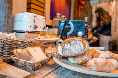 Aziz Anton am Arlberg. 10 Mart 2022. Otelin ahşap masasında taze ekmek ve sepet çeşitleri, ahşap masada çeşitli ekmekler.