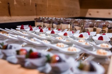 Çikolatalı pudingle hazırlanmış çilekler. Tatil köyündeki tezgahta çeşitli tatlı yiyecekler servis ediliyor. Tatil köyünde sergilenen lezzetli şekerlerin yakın çekimi.