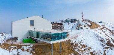 Alp dağlarındaki Alp restoranının panoramik manzarası ve müzesi. Karla kaplı gökyüzüne bakan füniküler istasyon. Kış boyunca modern turistik eğlence.