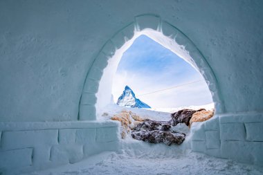 Meşhur madde boynuzu gökyüzüne karşı eskimo kulübesinden görülüyor. Buz evinin girişinde kar kürkü kaplamıştı. Kış boyunca Alp bölgesindeki donmuş kulübenin içi.