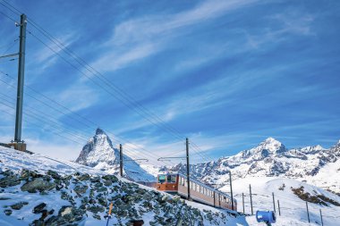Matterhorn Dağı 'ndan geçen tren. Demiryolu aracı Gornergrat istasyonuna doğru koşuyor. Kar, kış boyunca Alplerde mavi gökyüzüne karşı manzarayı kapladı.