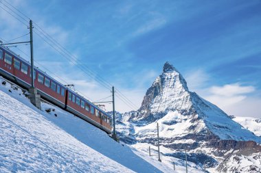 Tren Matterhorn Dağı 'ndan geçiyor. Demiryolu aracı gökyüzüne karşı Gornergrat istasyonuna doğru koşuyor. Kış boyunca Alpler karla kaplıydı..