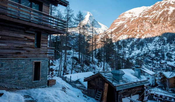 Matterhorn 'a karşı şehirdeki kayak merkezi. Berrak gökyüzüne karşı görkemli dağ sırasının üzerindeki güneş ışığının manzarası. Kış boyunca Alp bölgesindeki güzel şehir manzarası.