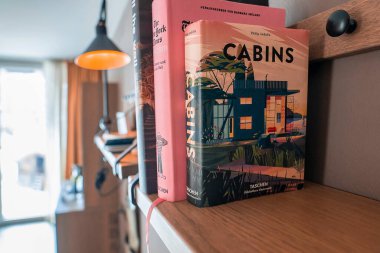 CERVO Oteli, Zermatt, İsviçre. 15 Mart 2022. Ahşap raftaki çeşitli kitapların yakın çekimi. Otel odasındaki duvara karşı dizilmişler. Tatil sırasında hobi edinme kavramı.