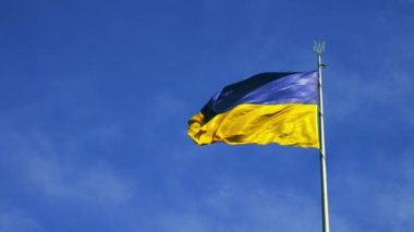 Ukraine flag waving in the wind. Seamless loop with highly detailed fabric texture against blue sky.
