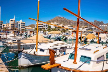 Limanda, binalara ve dağa karşı demirlemiş yatlar. Direkleri mavi gökyüzüne kenetlenmiş lüks beyaz yelkenliler. Denizcilik turizmi kavramı.