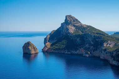 Akdeniz kıyısındaki kayalık uçurumun manzarası. Güneşli bir günde deniz kenarındaki dağ manzarası. Güzel adada manzaralı mavi okyanus.
