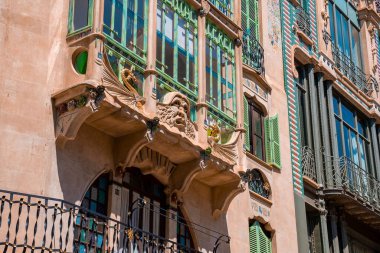 Dekorasyonlu ve balkonunda dekoratif tasarımı olan evin düşük açılı görüntüsü. Güneşli bir günde şehirde bir konut. Eski kentteki tarihi yapı.