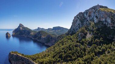Kayalık uçurum ve Akdeniz manzarası panoramik. Güneşli bir günde deniz kenarında ağaçlar büyür. Güzel adada Idyllic okyanusu.