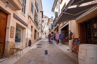 Mallorca, İspanya. 27 Nisan 2022. Ara sokakta tenteleri olan çeşitli mağazalar. Açık gökyüzüne karşı yerleşim bölgesindeki binalar. Yaz boyunca şehre gölge düşüyor..