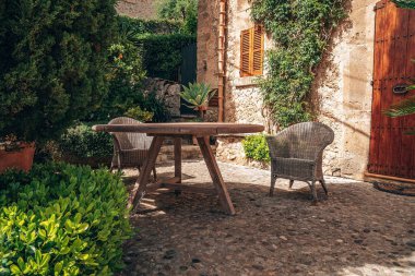 Masa ve sandalyeler evin dışında dizilmiş. Kasabadaki fabrikalara karşı boş oturma alanı. Yaz boyunca yerleşim bölgesinde yerleşim düzenlemesi