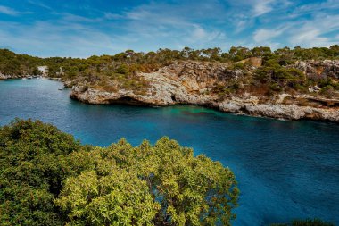 Kayalık uçurum ve Akdeniz 'in manzarası. Mavi gökyüzüne karşı adadaki dağın resimli görüntüsü. Yaz boyunca yüksek açılı güzel okyanus manzarası.