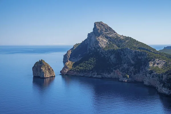 Akdeniz kıyısındaki kayalık uçurumun manzarası. Güneşli bir günde deniz kenarındaki dağ manzarası. Güzel adada manzaralı mavi okyanus.