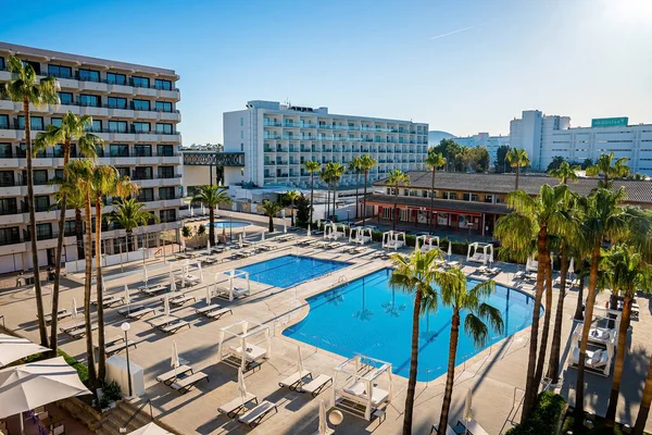 Yüksek açılı yüzme havuzlu tatil köyü manzarası. Berrak gökyüzüne karşı şezlongları olan modern lüks oteller. Yaz tatili kavramı.