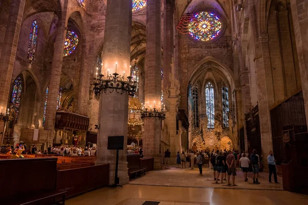 Mallorca, İspanya. 27 Nisan 2022. Turistler güzel La Seu Katedrali 'ni ziyaret edip dua ediyorlar. Şehirdeki ortaçağ gotik kilisesinde lekeli camlar. Süslü dini mekanların içinde..