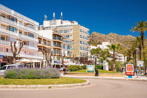 Mallorca, İspanya. 27 Nisan 2022. Döner kavşağın ortasında binalar var. Şehrin sokaklarında açık mavi gökyüzüne karşı tabelalar. Güneşli bir günde şehirde dağa karşı oteller.