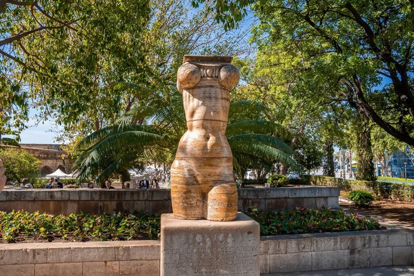 Ağaçlara ve bitkilere karşı kadın heykeli. Tarihi parkta heykel. Eski kasabadaki doğanın yaratıcı cazibesi.