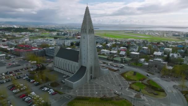 レイキャヴィクのハルグリムスカルカ教会の空中ビュー 4Kのアイスランドの景色 ハルグリムスカルカ ルーテル教会 リーフ エリクソン像 — ストック動画