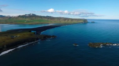Reynisfjara Vik 'te büyük dalgaları olan İzlanda siyah kumsalı. Hava sineması 4K videosu. Güzel İzlanda doğa kıyısı yukarıdan.