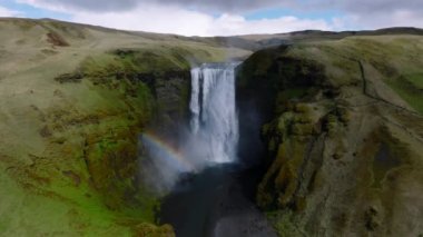 Gökkuşaklı ünlü Skogafoss şelalesi. Gün batımında İzlanda 'nın dramatik manzarası. Renkli gökyüzü manzaralı görkemli Skogafoss Şelalesi kırsalda.