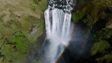 Gökkuşaklı ünlü Skogafoss şelalesi. Gün batımında İzlanda 'nın dramatik manzarası. Renkli gökyüzü manzaralı görkemli Skogafoss Şelalesi kırsalda.